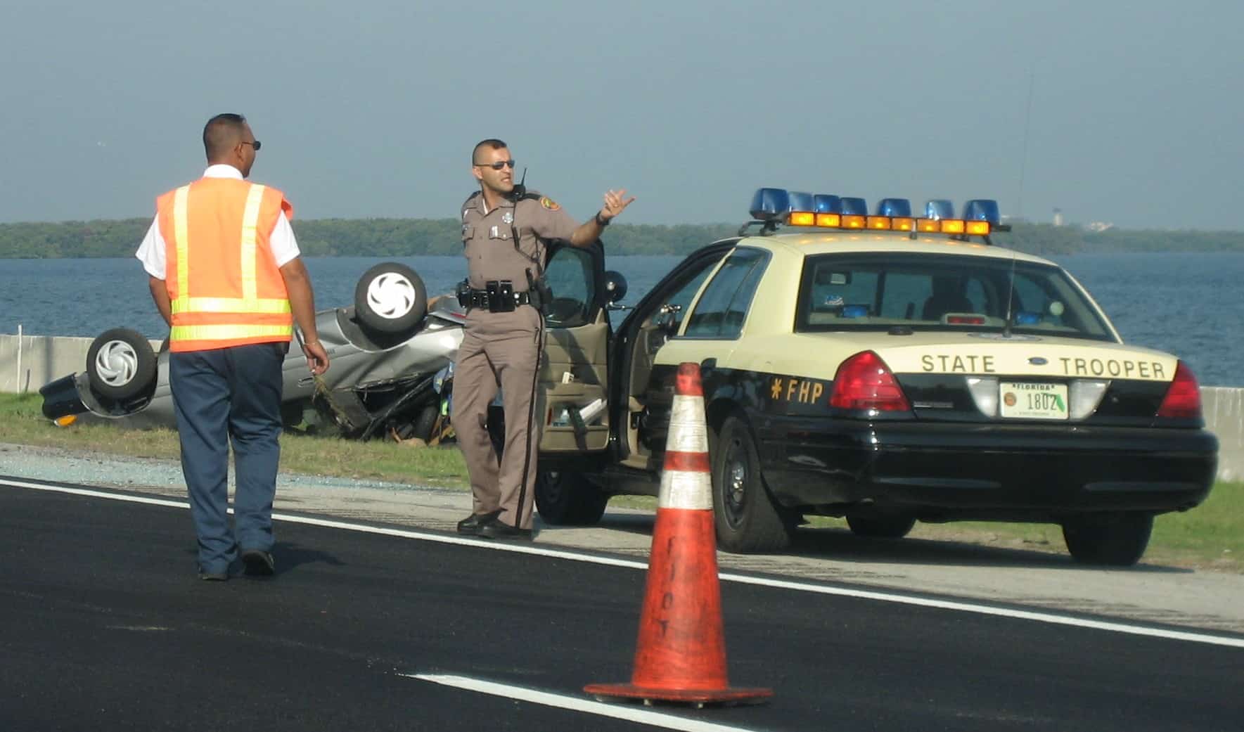 A Florida Highway Patrol trooper works the scene of a rollover crash