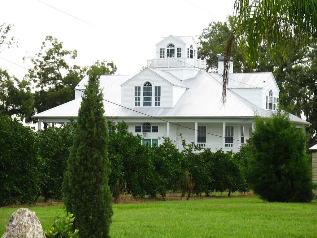 A single-family home beside an orange grove in Fort Denaud, Florida
